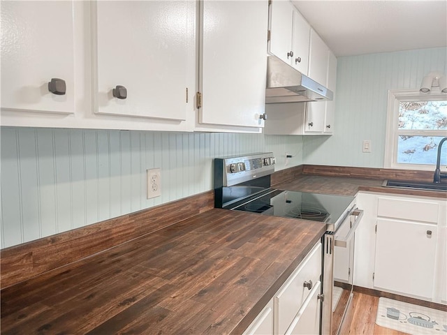 kitchen with a sink, under cabinet range hood, light wood-style floors, stainless steel electric range oven, and white cabinets