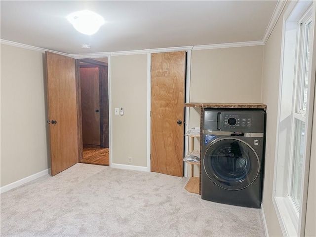 clothes washing area featuring laundry area, carpet, washer / dryer, baseboards, and crown molding