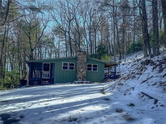 exterior space featuring a sunroom and a chimney