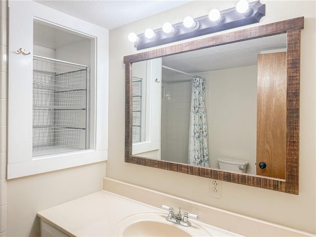 bathroom with toilet, a textured ceiling, vanity, and a shower with shower curtain