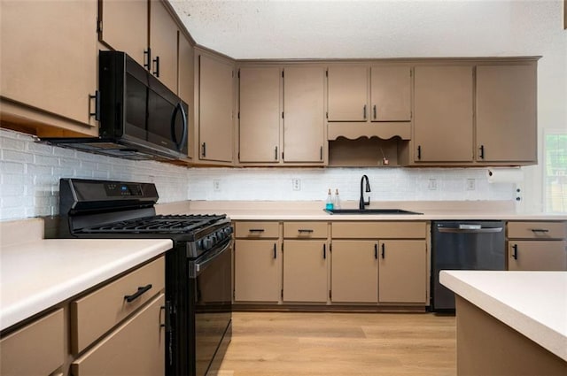409 Cold Springs Ln, Mcdonough, GA 30252 - kitchen featuring black appliances, a sink, light wood-style floors, light countertops, and decorative backsplash