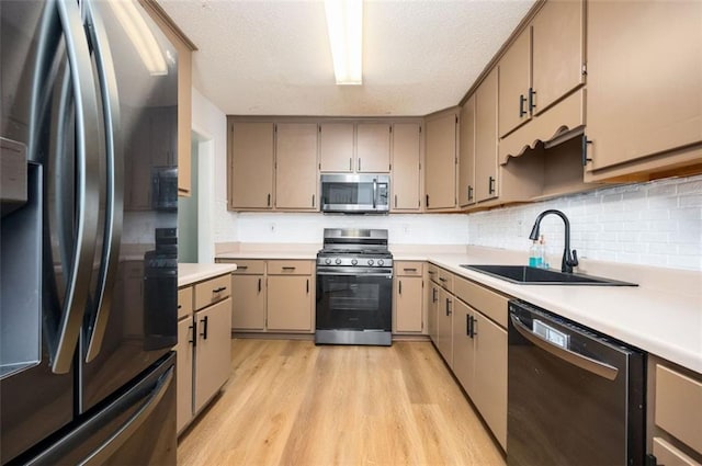 409 Cold Springs Ln, Mcdonough, GA 30252 - kitchen featuring appliances with stainless steel finishes, a sink, light wood-type flooring, and light countertops