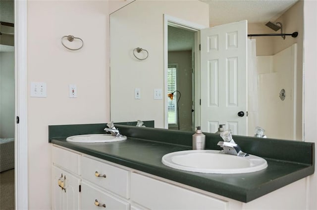 409 Cold Springs Ln, Mcdonough, GA 30252 - full bathroom featuring double vanity, a shower, and a textured ceiling