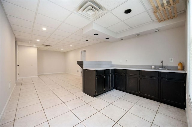 409 Cold Springs Ln, Mcdonough, GA 30252 - kitchen with dark cabinets, a sink, light countertops, light tile patterned flooring, and a drop ceiling
