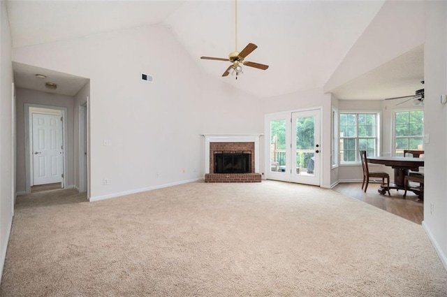 409 Cold Springs Ln, Mcdonough, GA 30252 - unfurnished living room featuring a ceiling fan, carpet, high vaulted ceiling, baseboards, and a brick fireplace