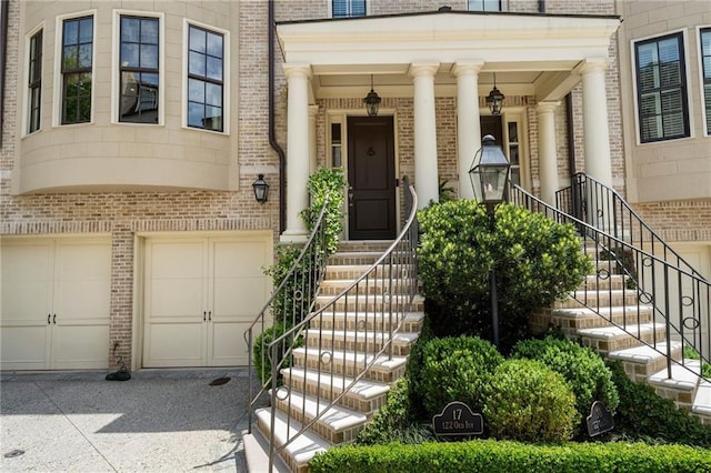 122 Old Ivy Rd NE Unit 17, Atlanta, GA 30342 - doorway to property with brick siding, an attached garage, and driveway