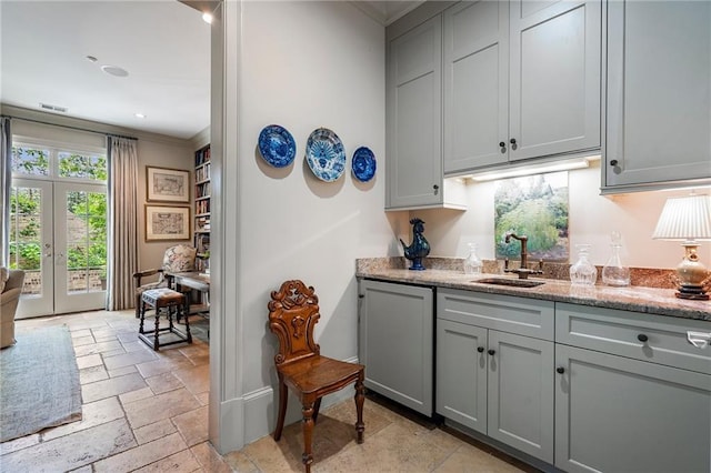 122 Old Ivy Rd NE Unit 17, Atlanta, GA 30342 - bar featuring a sink, stone tile floors, ornamental molding, and french doors