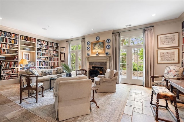 122 Old Ivy Rd NE Unit 17, Atlanta, GA 30342 - living room featuring stone tile flooring, crown molding, recessed lighting, french doors, and a lit fireplace