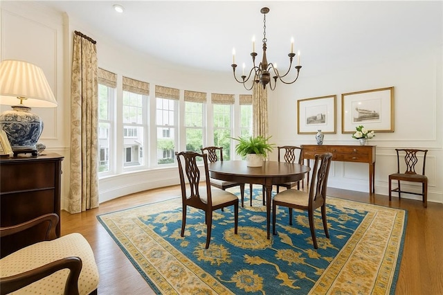 122 Old Ivy Rd NE Unit 17, Atlanta, GA 30342 - dining space with a chandelier, wood finished floors, and a decorative wall