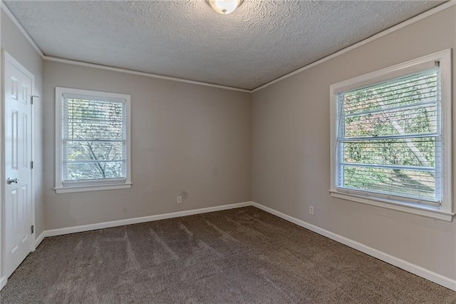 spare room with dark colored carpet, a textured ceiling, a wealth of natural light, and ornamental molding