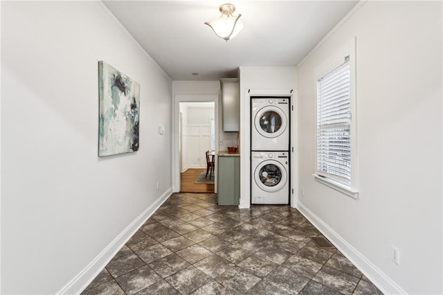 clothes washing area featuring stacked washer and clothes dryer