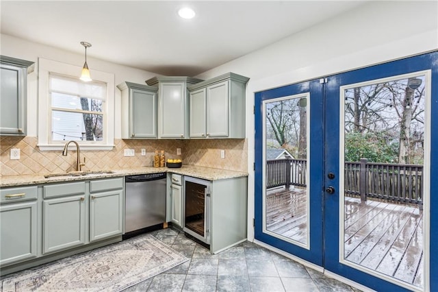 kitchen with sink, dishwasher, french doors, decorative light fixtures, and beverage cooler