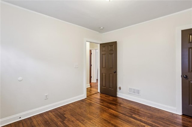 spare room with crown molding and dark hardwood / wood-style floors