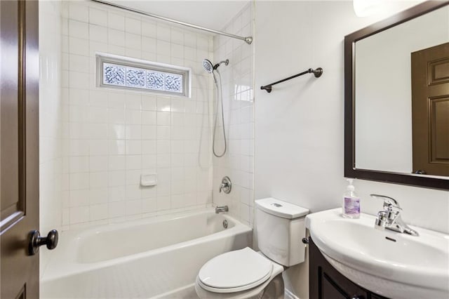 full bathroom featuring tiled shower / bath, vanity, and toilet