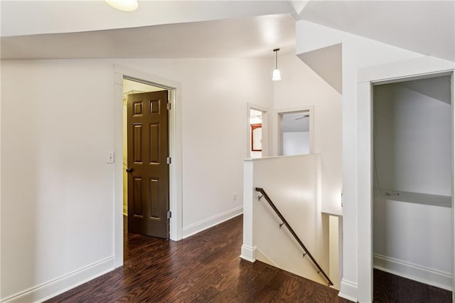 corridor featuring dark wood-type flooring and lofted ceiling