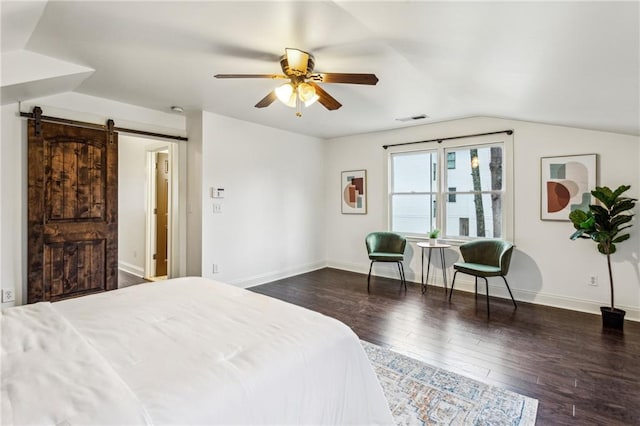 bedroom with lofted ceiling, dark hardwood / wood-style floors, a barn door, and ceiling fan