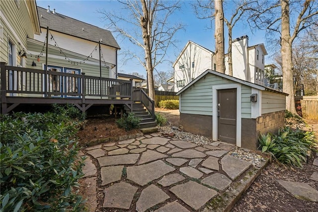 view of patio / terrace featuring a wooden deck and an outbuilding