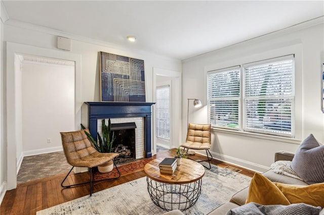 living area featuring crown molding, a fireplace, and dark hardwood / wood-style flooring