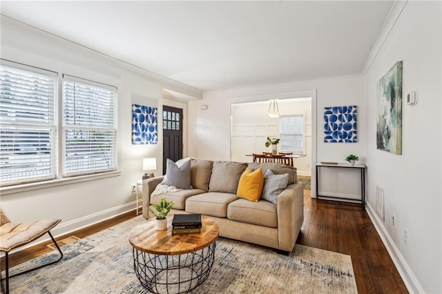 living room with dark wood-type flooring and ornamental molding