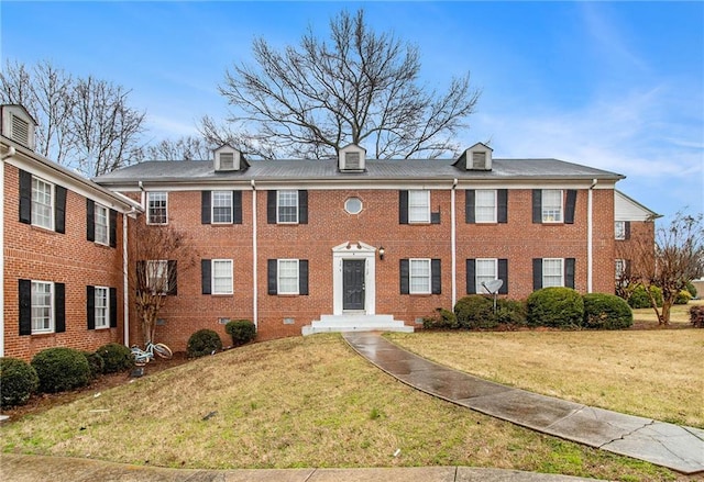 view of front of property featuring crawl space, brick siding, and a front lawn