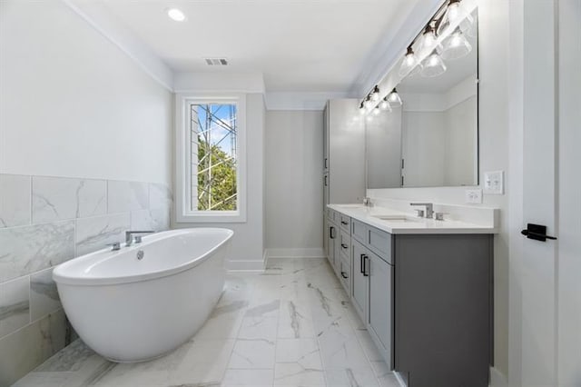 bathroom featuring a bathtub, vanity, and tile walls