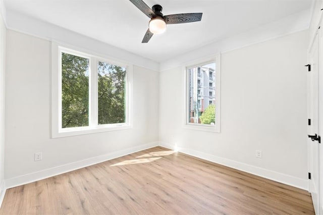 empty room with ceiling fan, a healthy amount of sunlight, and light wood-type flooring