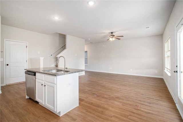 2291 Elise Way, Hampton, GA 30228 - kitchen with dishwasher, a ceiling fan, stone counters, white cabinetry, and a kitchen island with sink