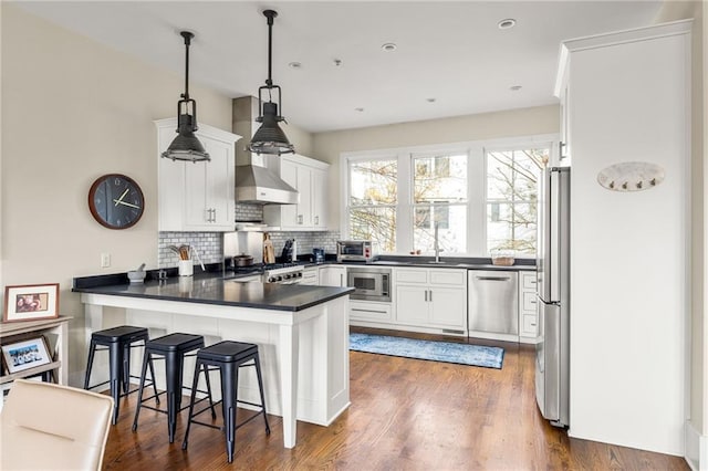 9129 Selborne Ln, Chattahoochee Hills, GA 30268 - kitchen with kitchen peninsula, white cabinetry, hanging light fixtures, and appliances with stainless steel finishes