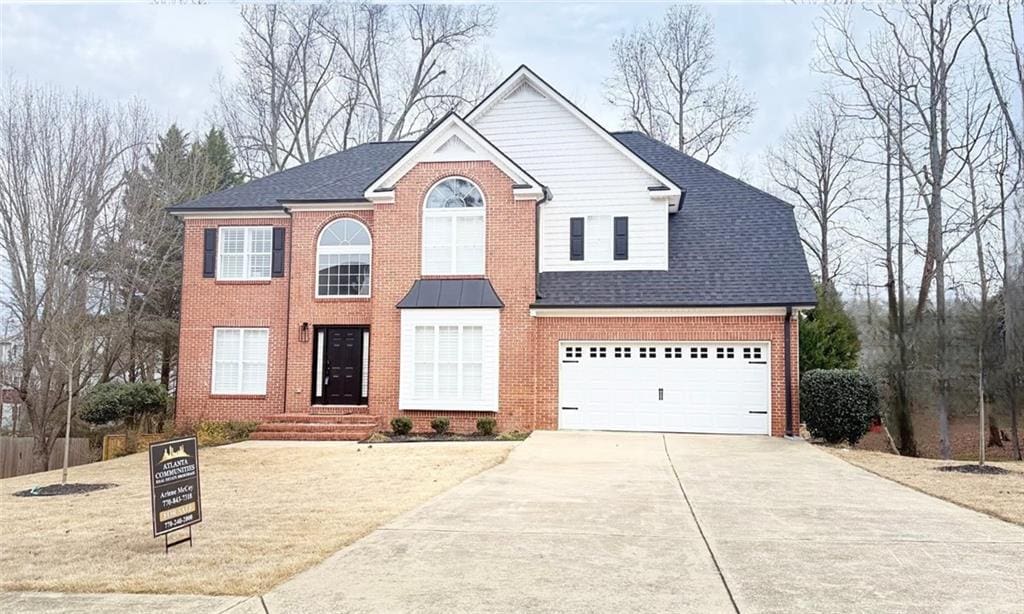 view of front facade featuring a garage, driveway, roof with shingles, and brick siding