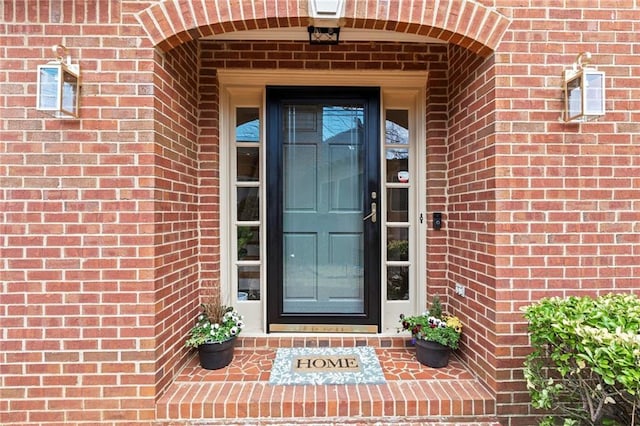 entrance to property featuring brick siding