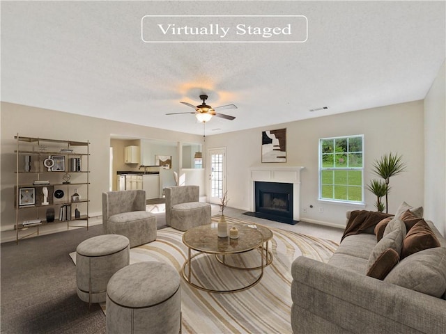 living room with a healthy amount of sunlight, ceiling fan, and light carpet