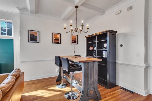 dining area with light wood-style flooring, coffered ceiling, visible vents, baseboards, and beamed ceiling
