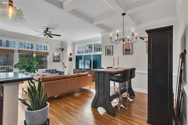 living area with a ceiling fan, beam ceiling, coffered ceiling, and wood finished floors