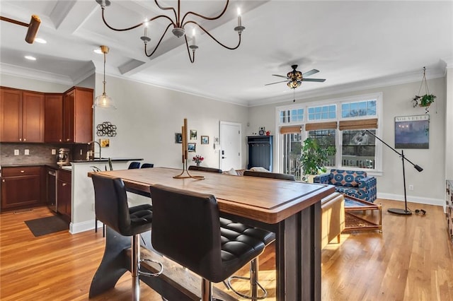 dining room with ornamental molding, baseboards, light wood finished floors, and ceiling fan with notable chandelier