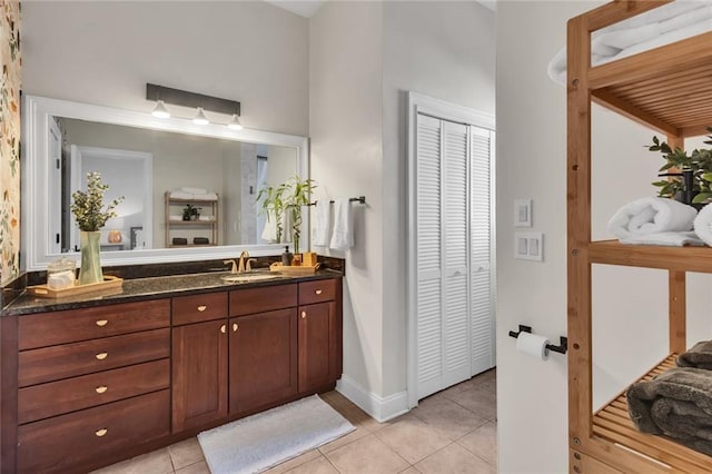 bathroom featuring tile patterned flooring, a closet, vanity, and baseboards