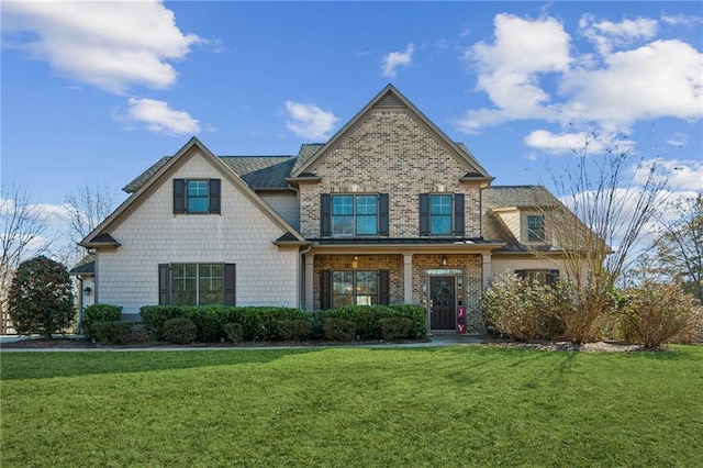 craftsman house with a front lawn and brick siding