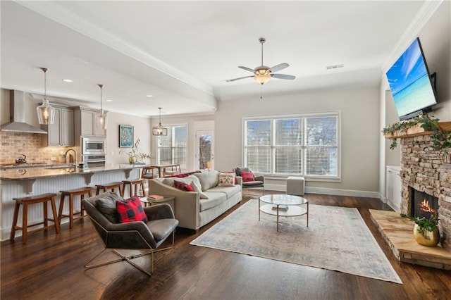 living area with dark wood-type flooring, visible vents, and a stone fireplace