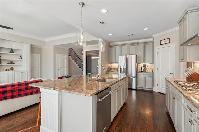 kitchen featuring dark wood-type flooring, light stone countertops, stainless steel appliances, crown molding, and a sink