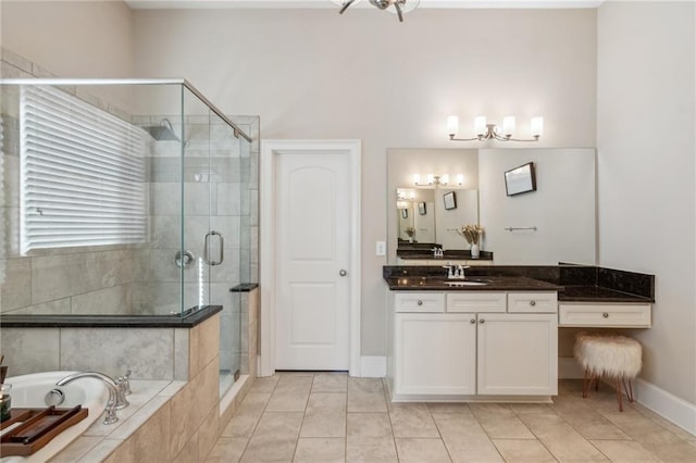 full bath with tiled bath, a shower stall, vanity, tile patterned flooring, and baseboards