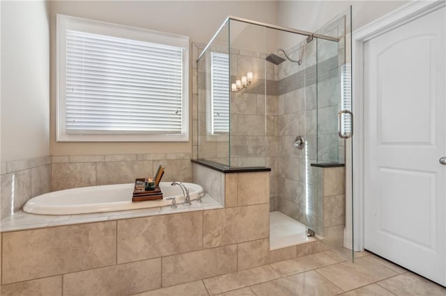 bathroom featuring tile patterned flooring, a shower stall, and a bath