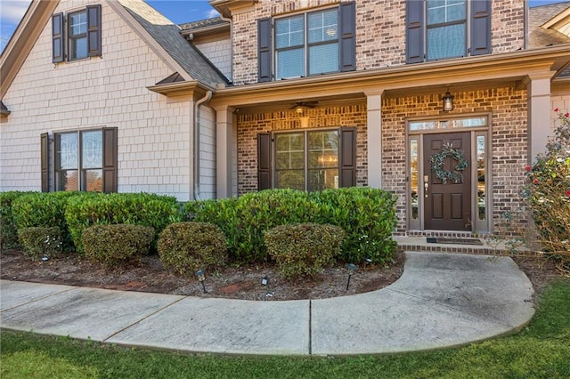 property entrance featuring brick siding and roof with shingles