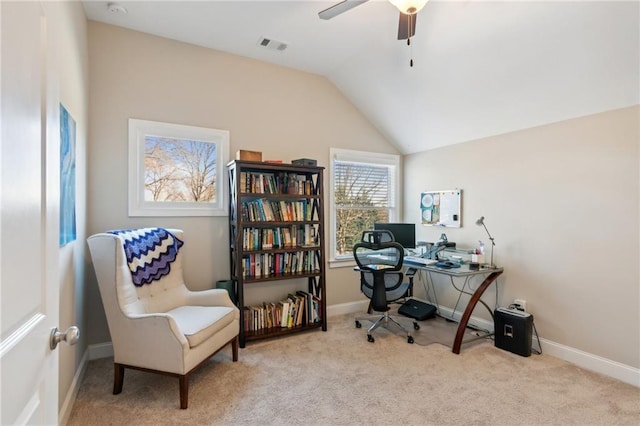 carpeted home office with lofted ceiling, a ceiling fan, visible vents, and baseboards