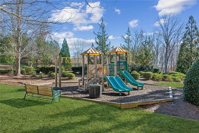 community play area with fence and a yard