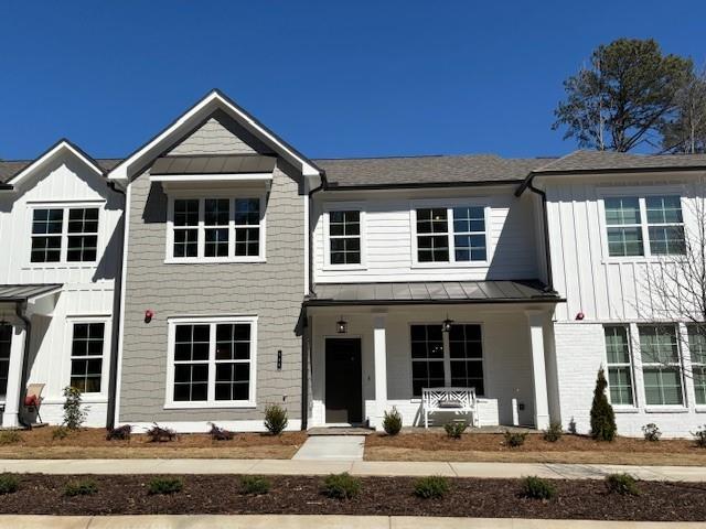 view of front of home with a standing seam roof, metal roof, board and batten siding, and covered porch