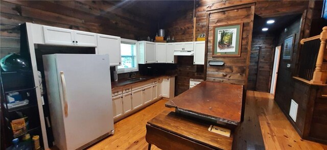 1251 Bar T Ranch Rd, Talking Rock, GA 30175 - kitchen featuring light hardwood / wood-style floors, wooden walls, sink, white fridge, and white cabinetry