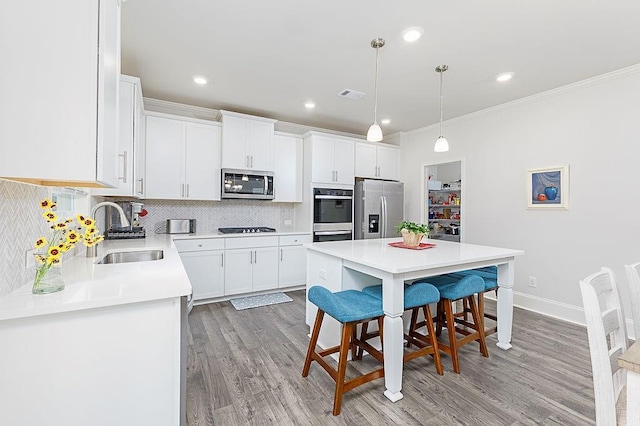 895 Garnet Dr, Acworth, GA 30101 - kitchen with stainless steel appliances, a kitchen breakfast bar, light wood-type flooring, backsplash, and light countertops