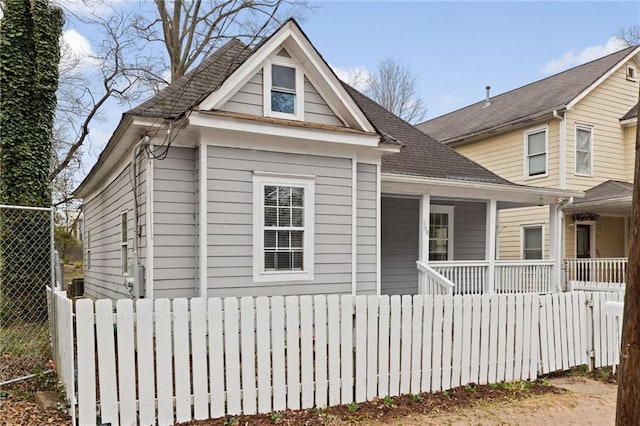 view of front of property with a shingled roof, fence, and a porch