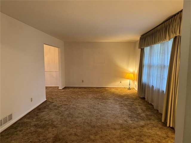 unfurnished room featuring dark carpet