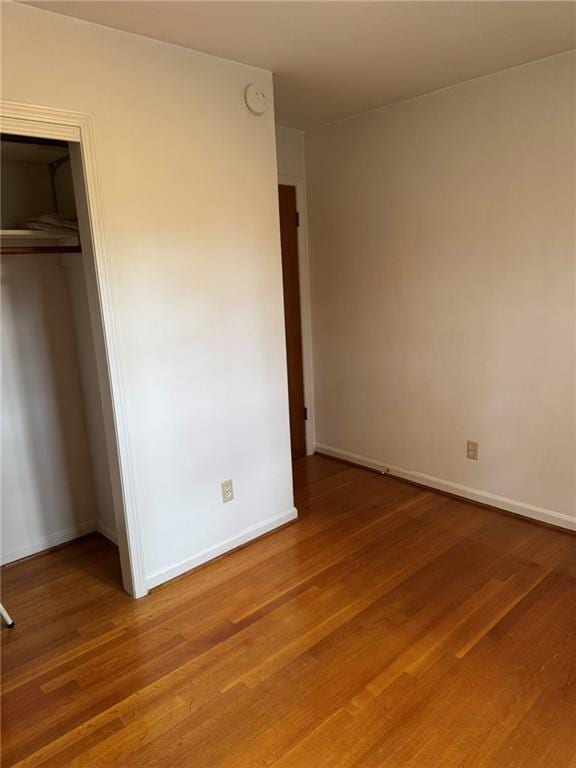 unfurnished bedroom with wood-type flooring and a closet