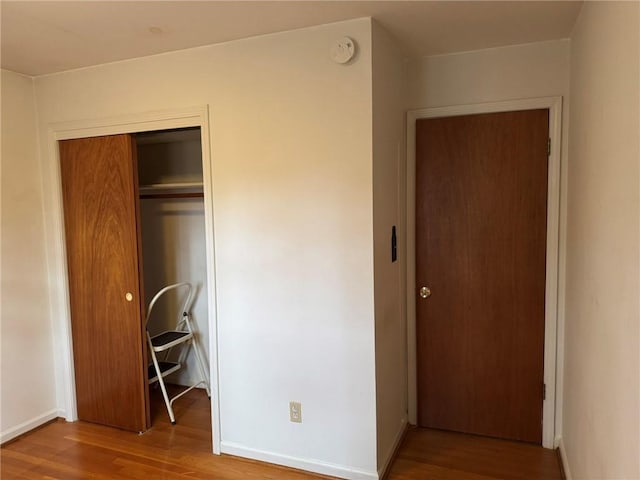 unfurnished bedroom with wood-type flooring and a closet